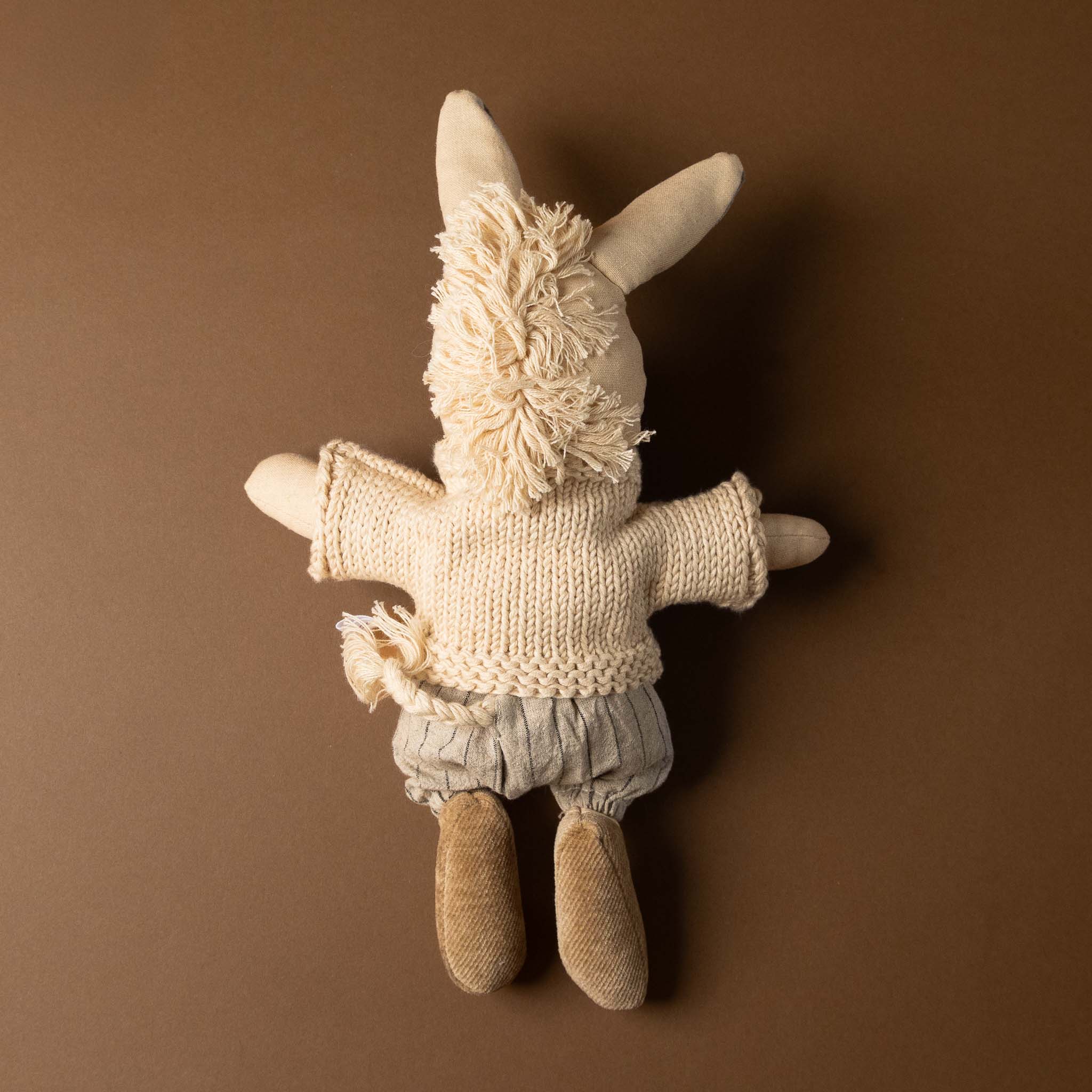 cedric-the-donkey Stuffed animal toy wearing a sweater and pants on a brown background