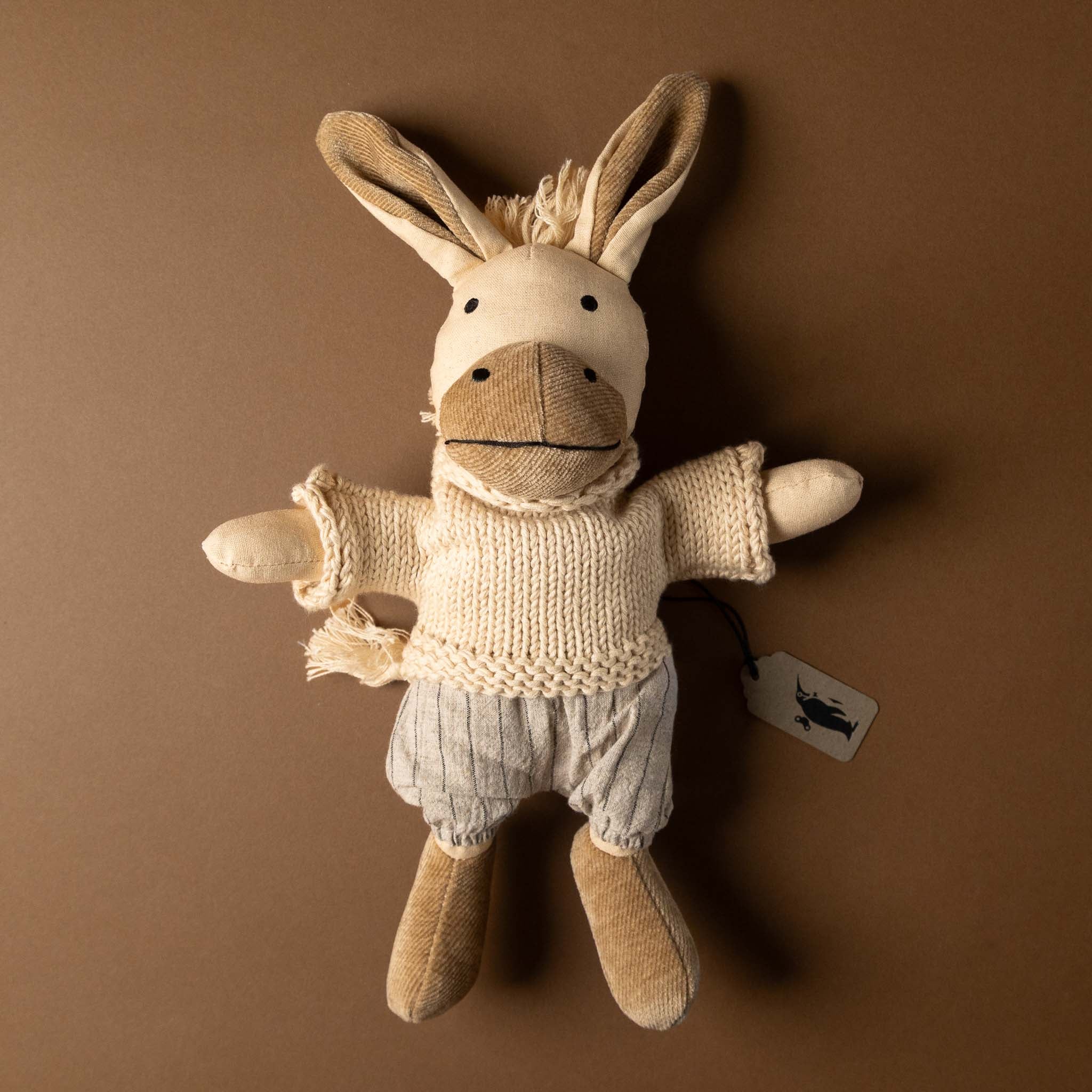 cedric-the-donkey Stuffed animal toy wearing a sweater and pants on a brown background