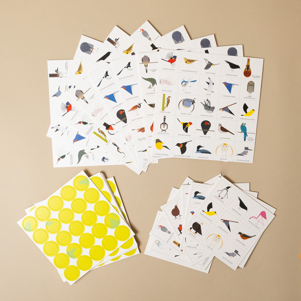 charley-harpers-bird-bingo Collection of illustrated cards and yellow circular stickers on a beige background