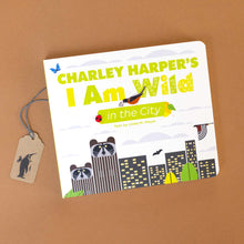 Load image into Gallery viewer, charley-harpers-i-am-wild-in-the-city-board-book-cover-with-skyscrapers-with-raccoon-heads-and-birds-flying