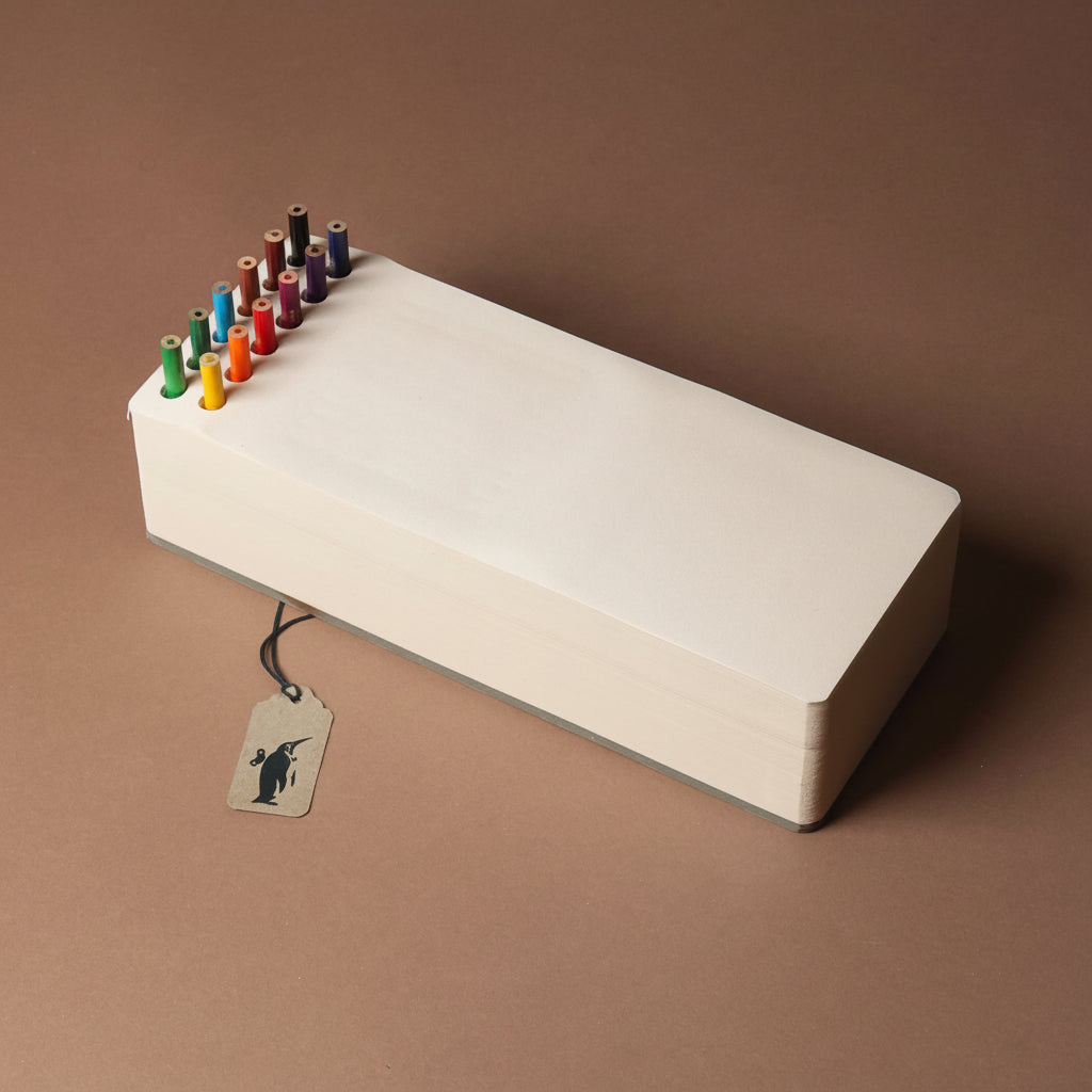 chunky-jotblock-sketch-pad-brick White rectangular paper block with colorful pencils on a brown background