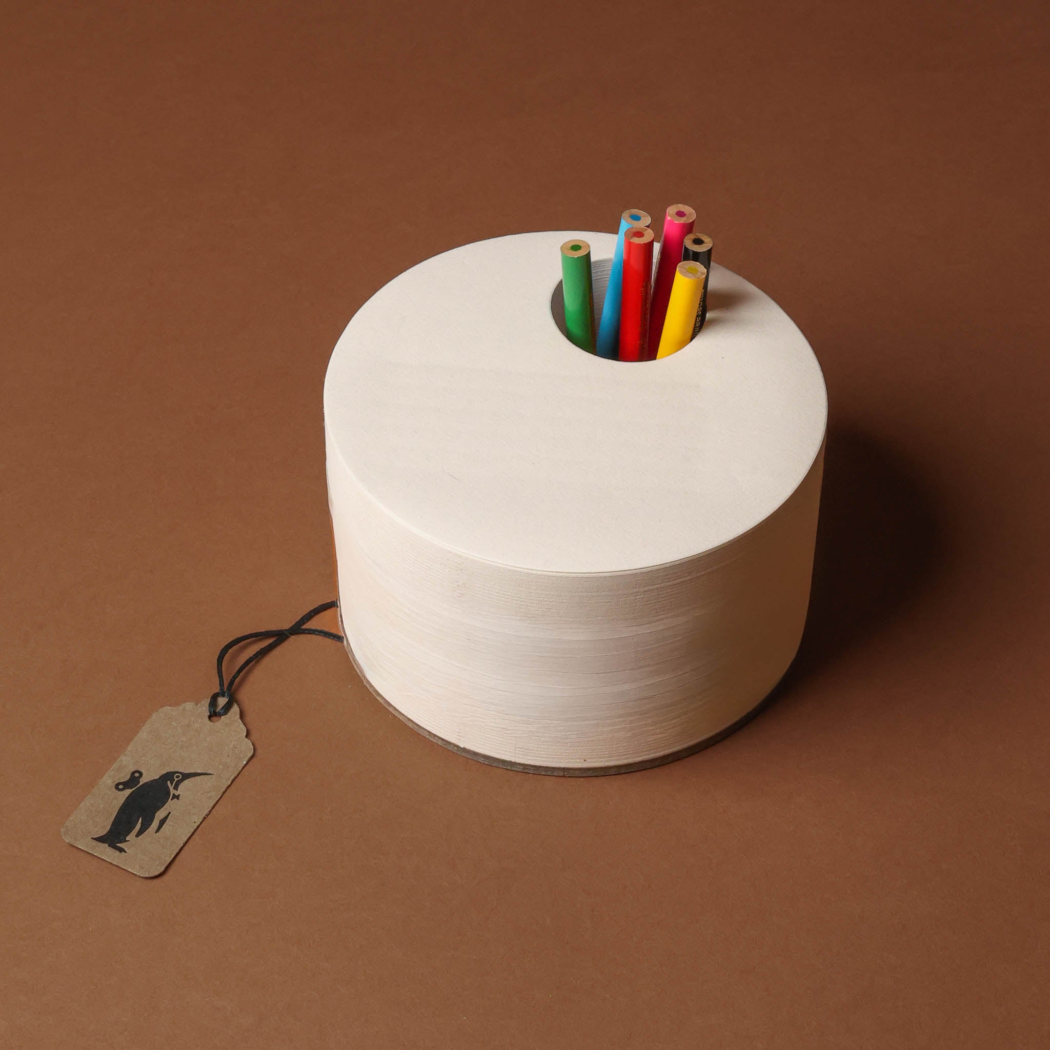 White spool with colorful pencils on a brown background