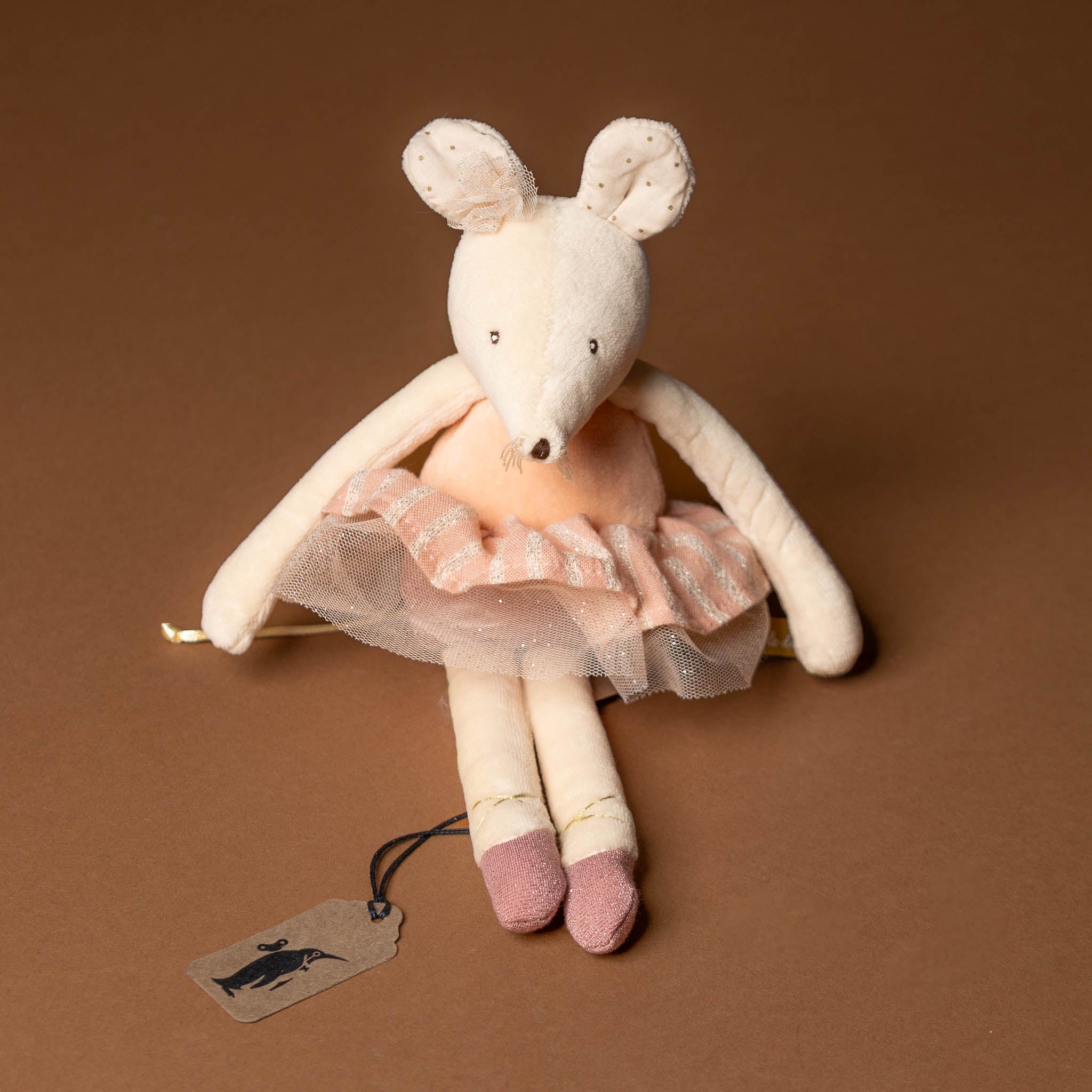 dance-mouse-rose Stuffed mouse toy in a pink dress with a tag on a brown background