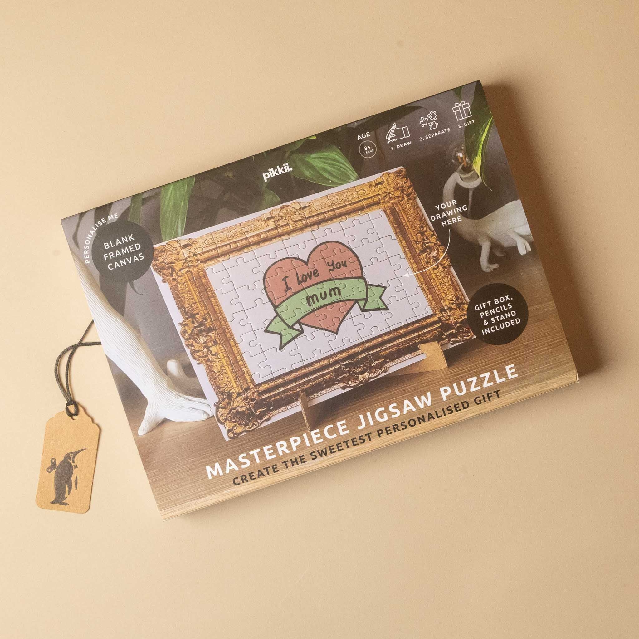 A boxed jigsaw puzzle gift set photographed on a warm beige background. The package shows a framed canvas-style puzzle design with the text 'I love you mum' of draw-your-own-jigsaw-puzzle-gift-set and 'Create the sweetest personalised gift.
