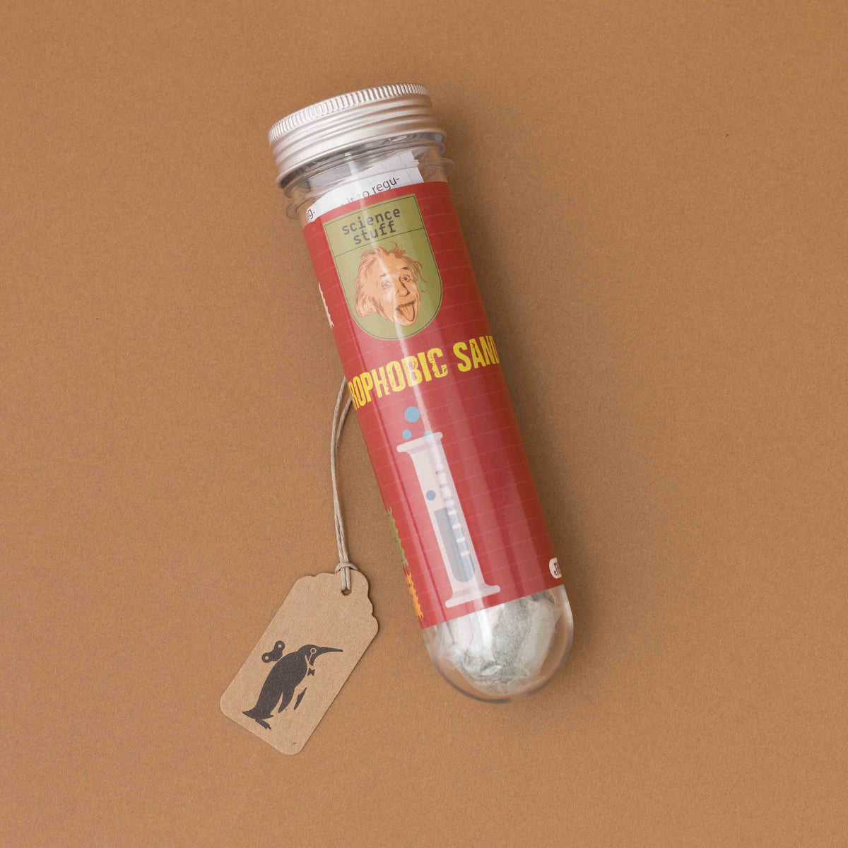 A clear plastic vial with a white cap containing white powder, wrapped in a red label that reads 'science stuff' and 'hydrOPHIbIC SAND'. A small kraft paper tag with a black bird logo hangs from the tube.