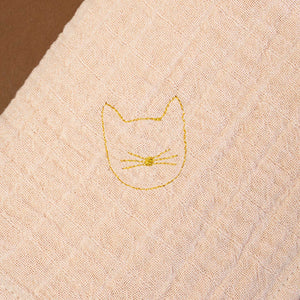 close-up-of-blush-fabric-with-gold-embroidered-kitten
