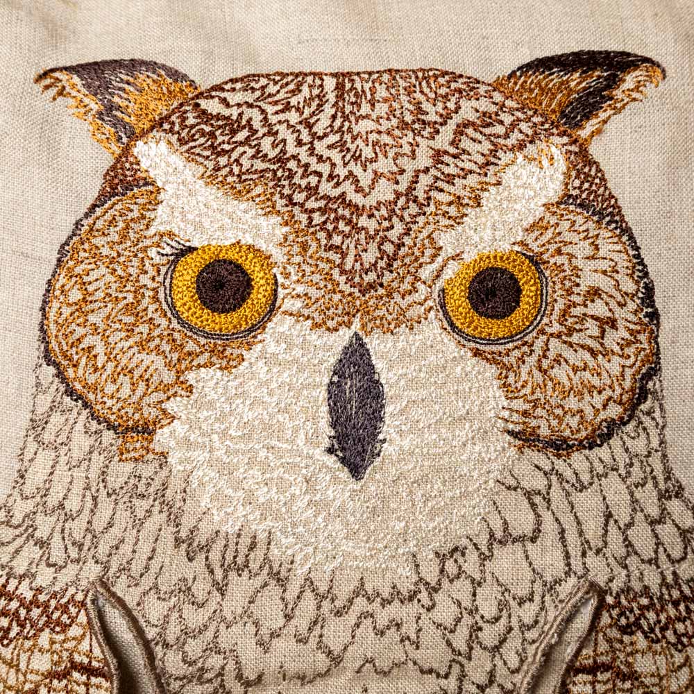 embroidered-pocket-pillow--mama-owl Embroidered owl face detail on fabric with detailed stitching.