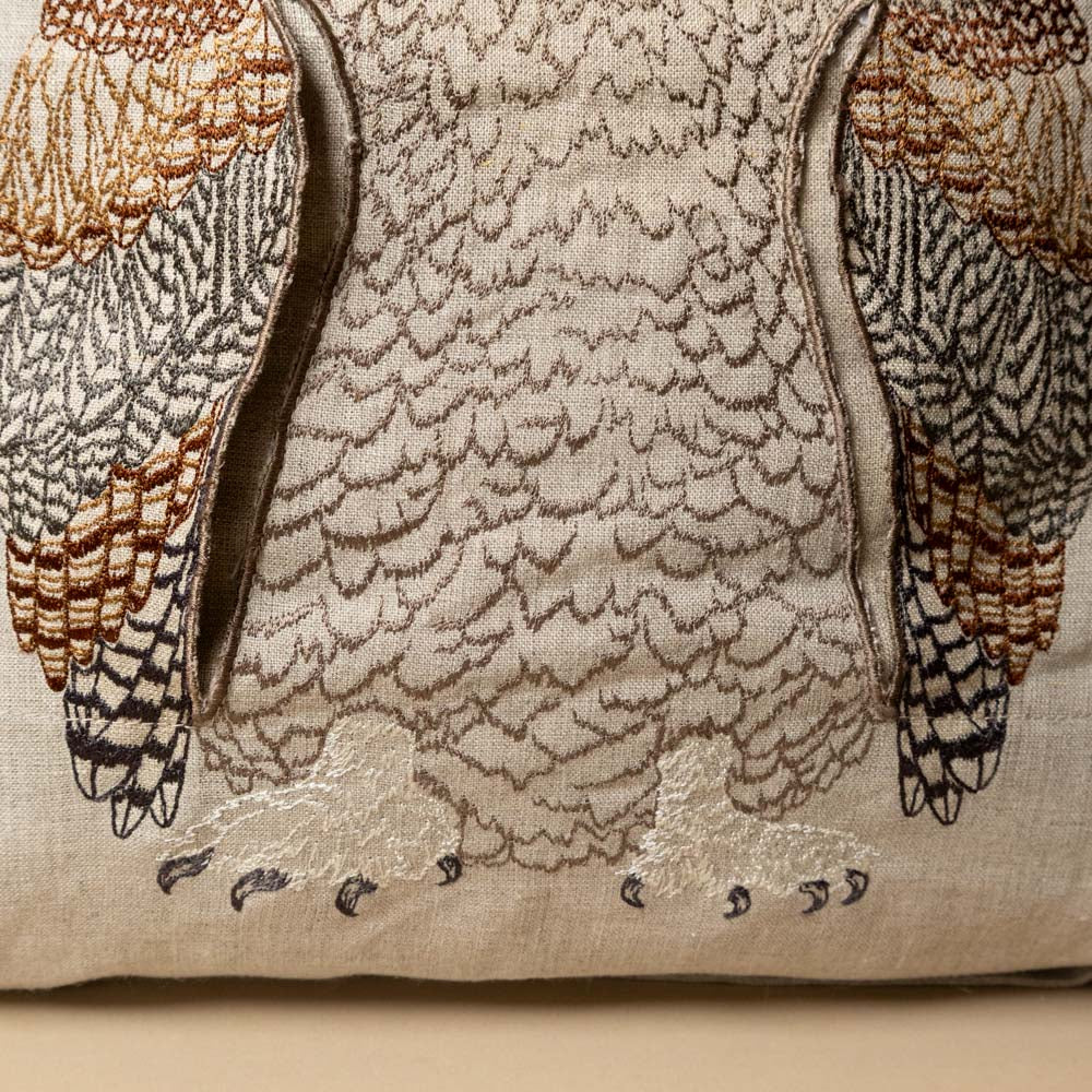 embroidered-pocket-pillow--mama-owl with Embroidered owl detail of talons on a beige fabric background