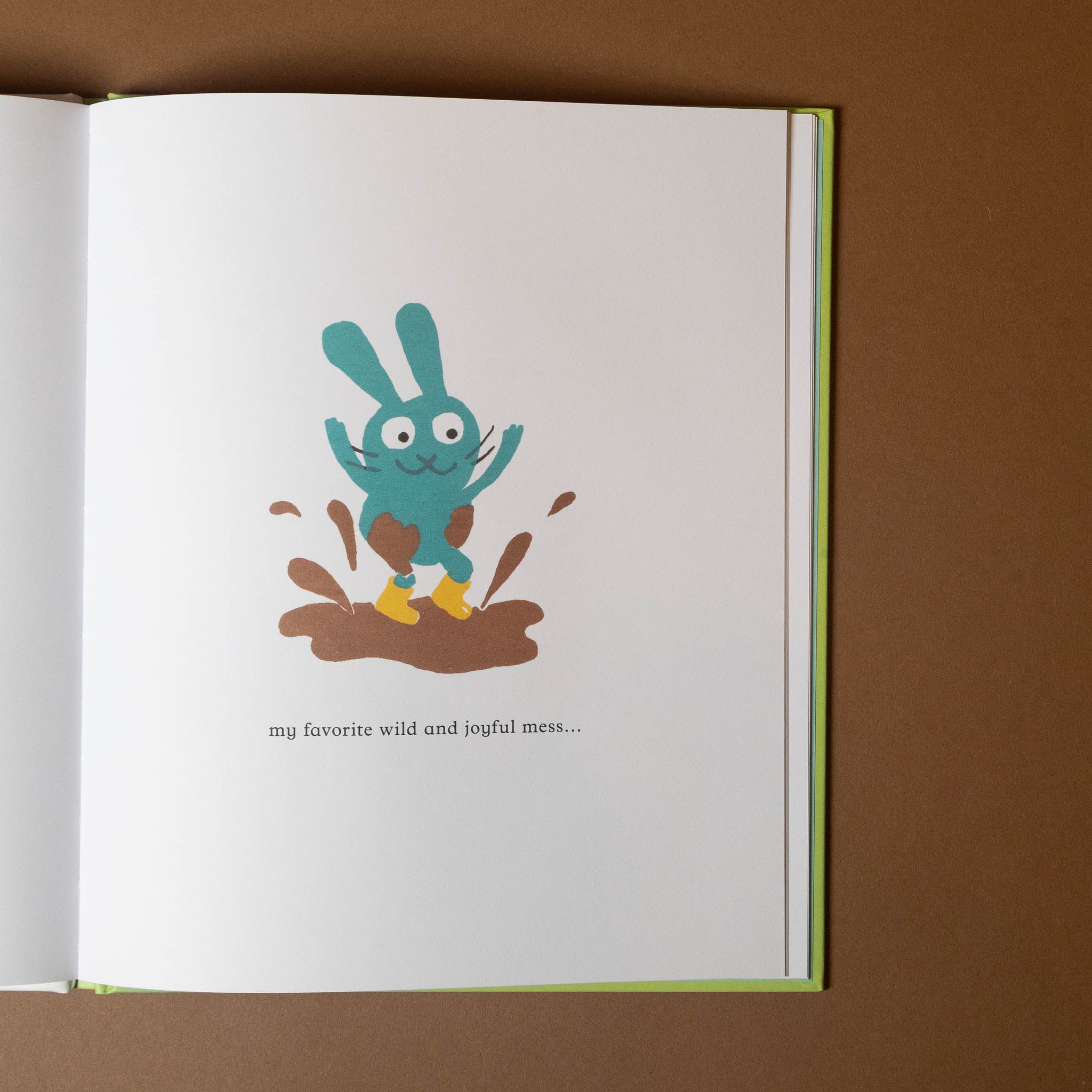 Illustration of a blue creature in a puddle on a book page with text.