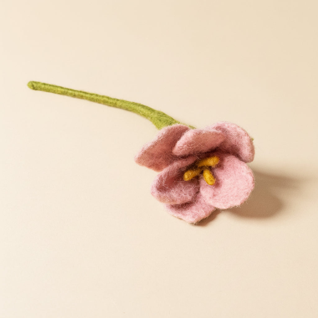 Pink felted flower on a beige background