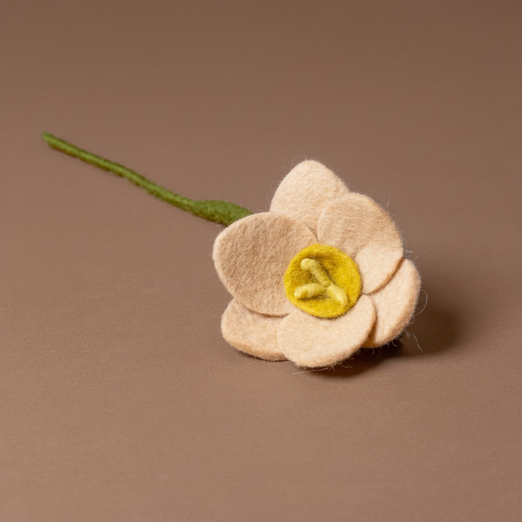 Felted flower with a green stem on a brown background