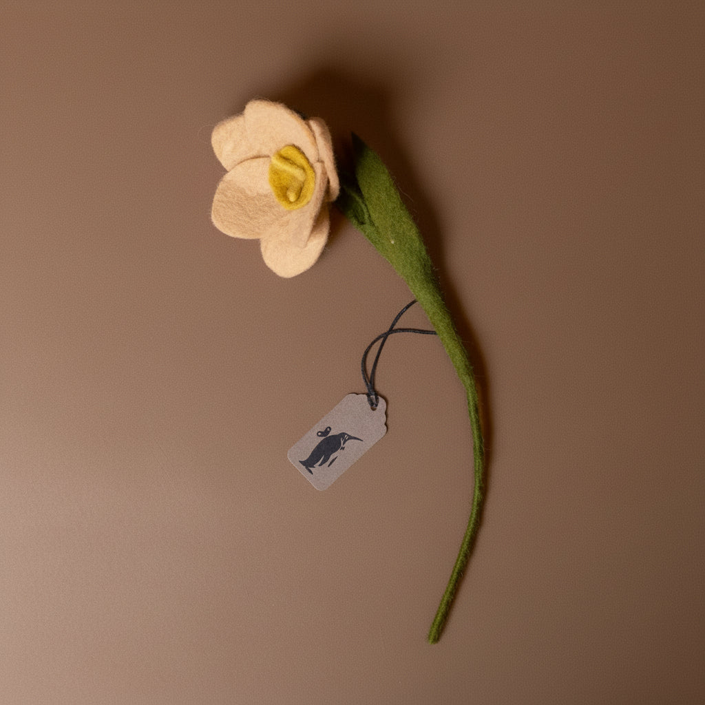 Felted flower with a tag on a brown background