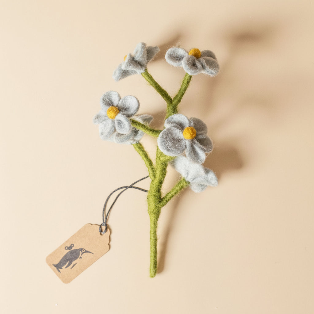 Felted flower branch with a tag on a beige background