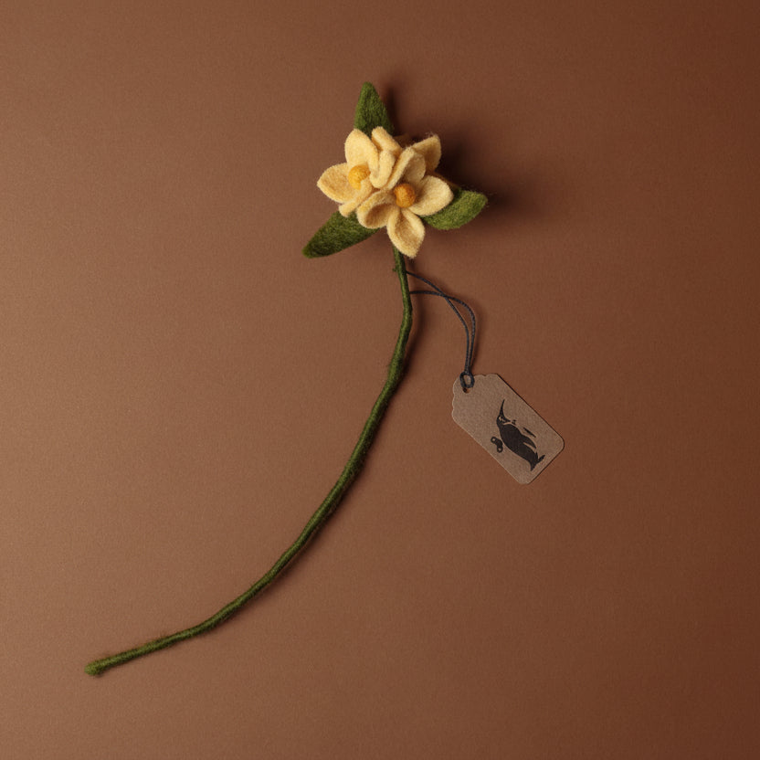 Felted butter yellow flower with green stem on a brown background