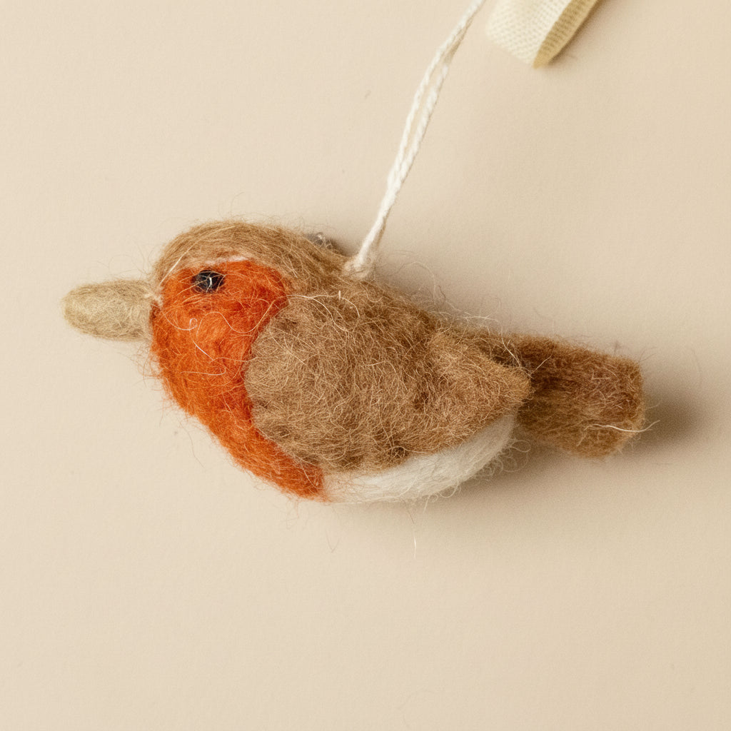 Felted robin decoration on a beige background