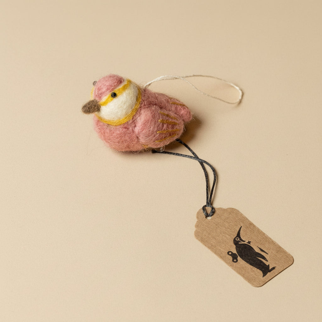 Pink bird-shaped ornament with a tag on a beige background
