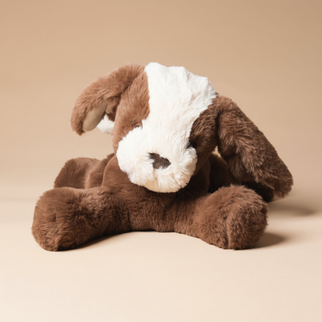 Brown plush floppy-mutt-cocoa toy with a white face on a beige background