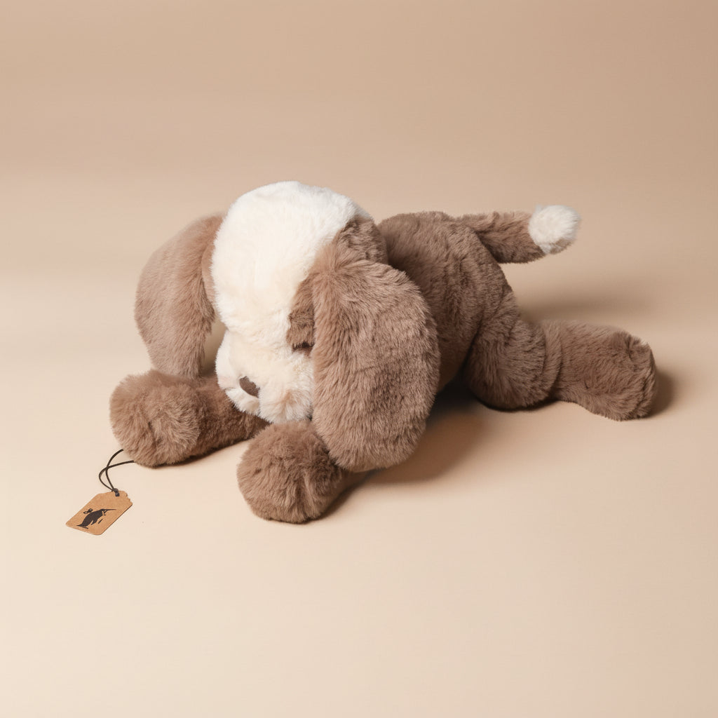 Brown plush loppy-mutt-toffee toy lying on a beige background