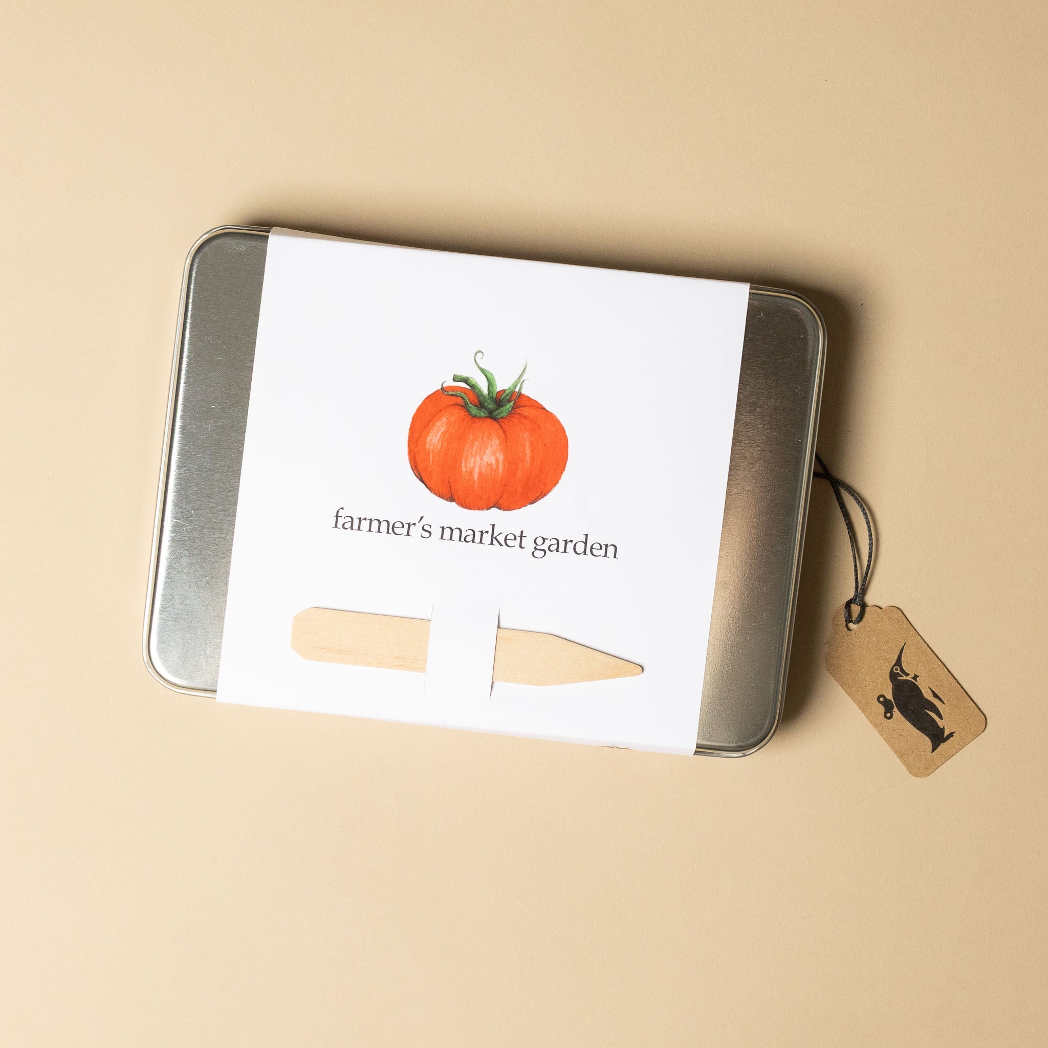 Metal tin with a tomato illustration and 'farmer's market garden' text on a beige background