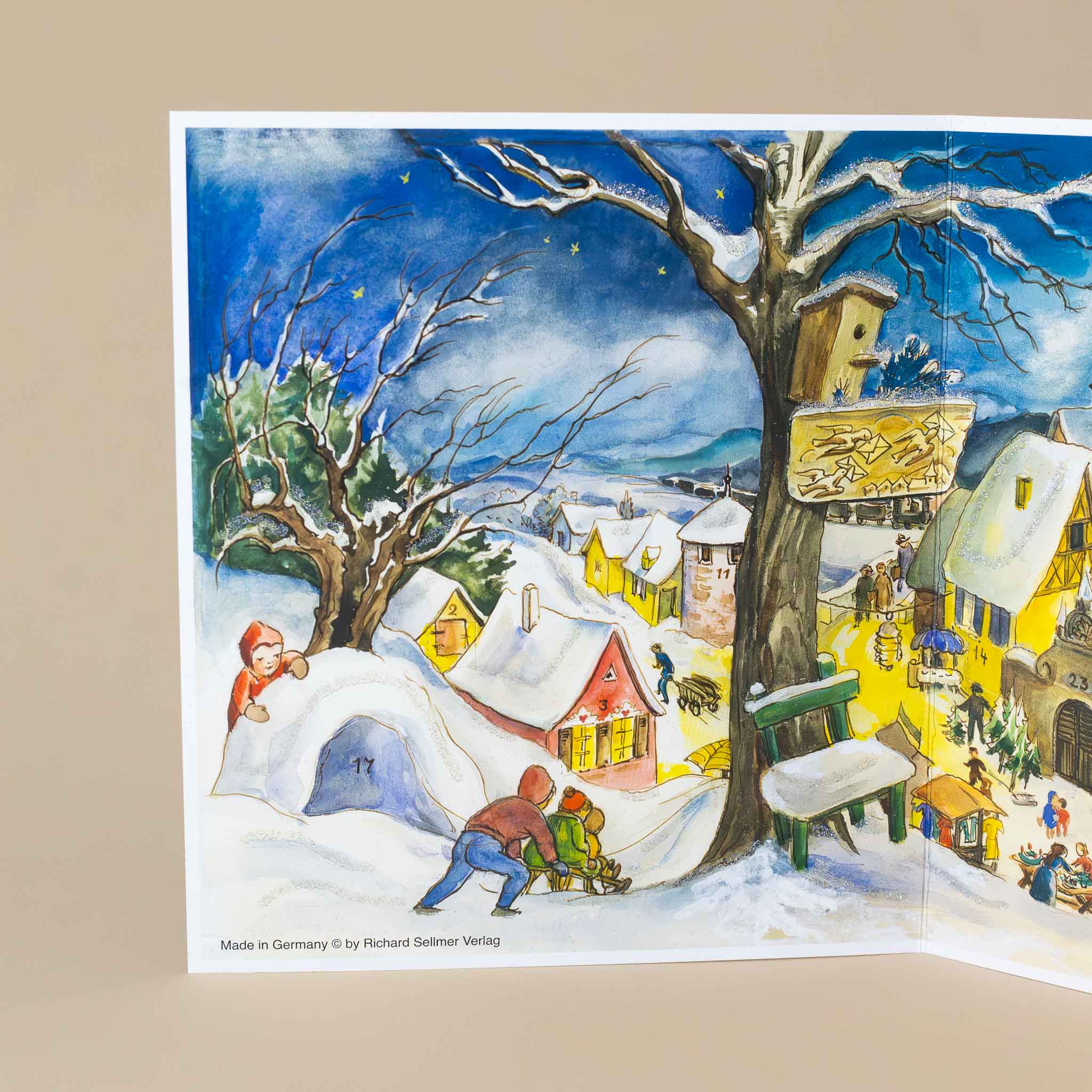 german-advent-calendar-winter-village-warmly-lit-buildings-with-snow-capped-roofs-and-people-busy-playing-and-working-in-town-children-building-an-igloo-and-sledding