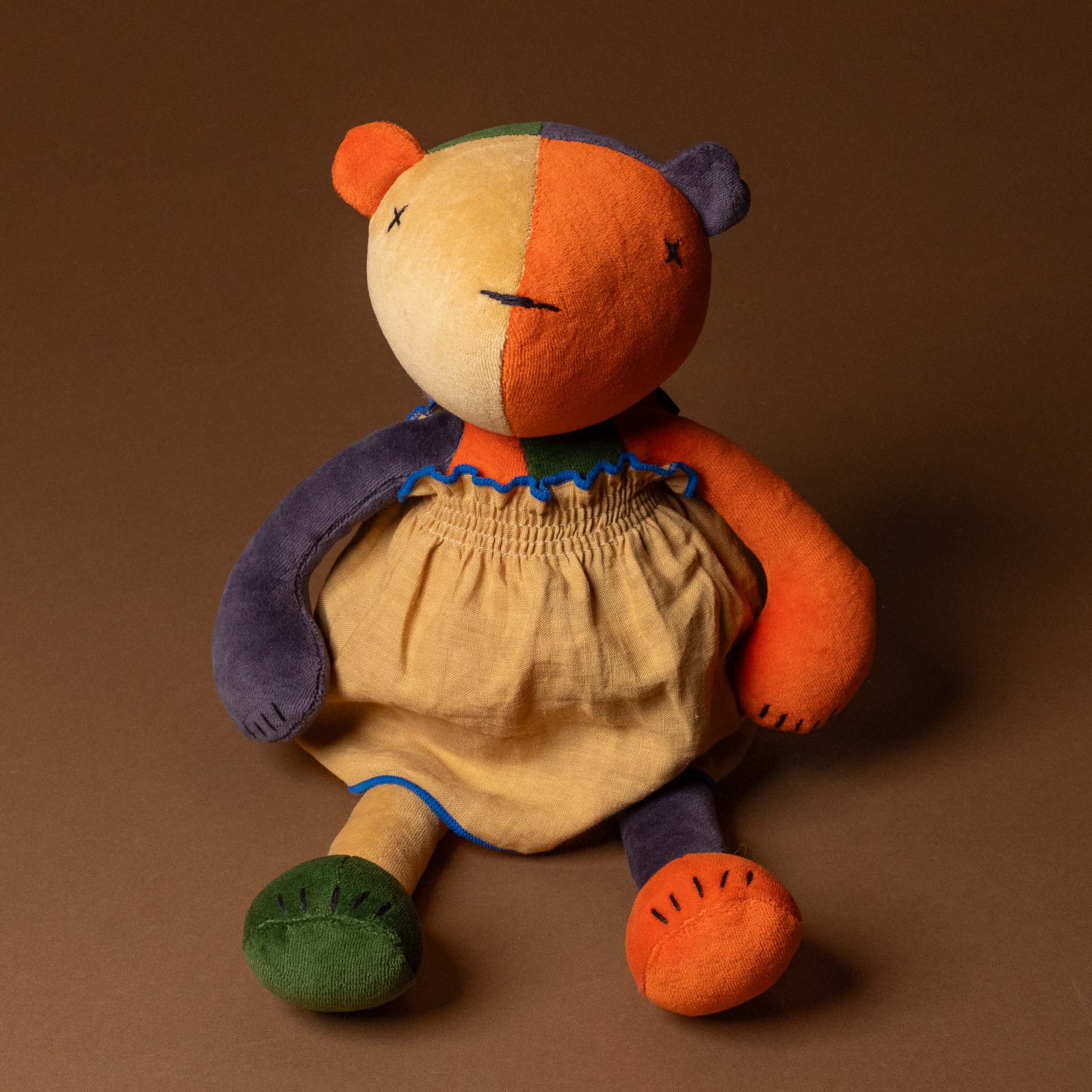 Colorful teddy bear with a patchwork design in grande-outfit-linen-dress-ochre on a brown background