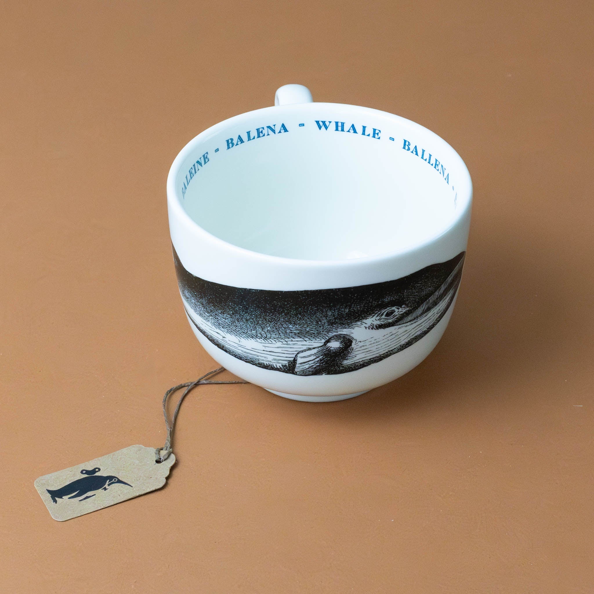 white-grande-stoneware-cup-black-illustration-whale-with-the-word-whale-in-blue-in-several-languages-on-interior-of-cup