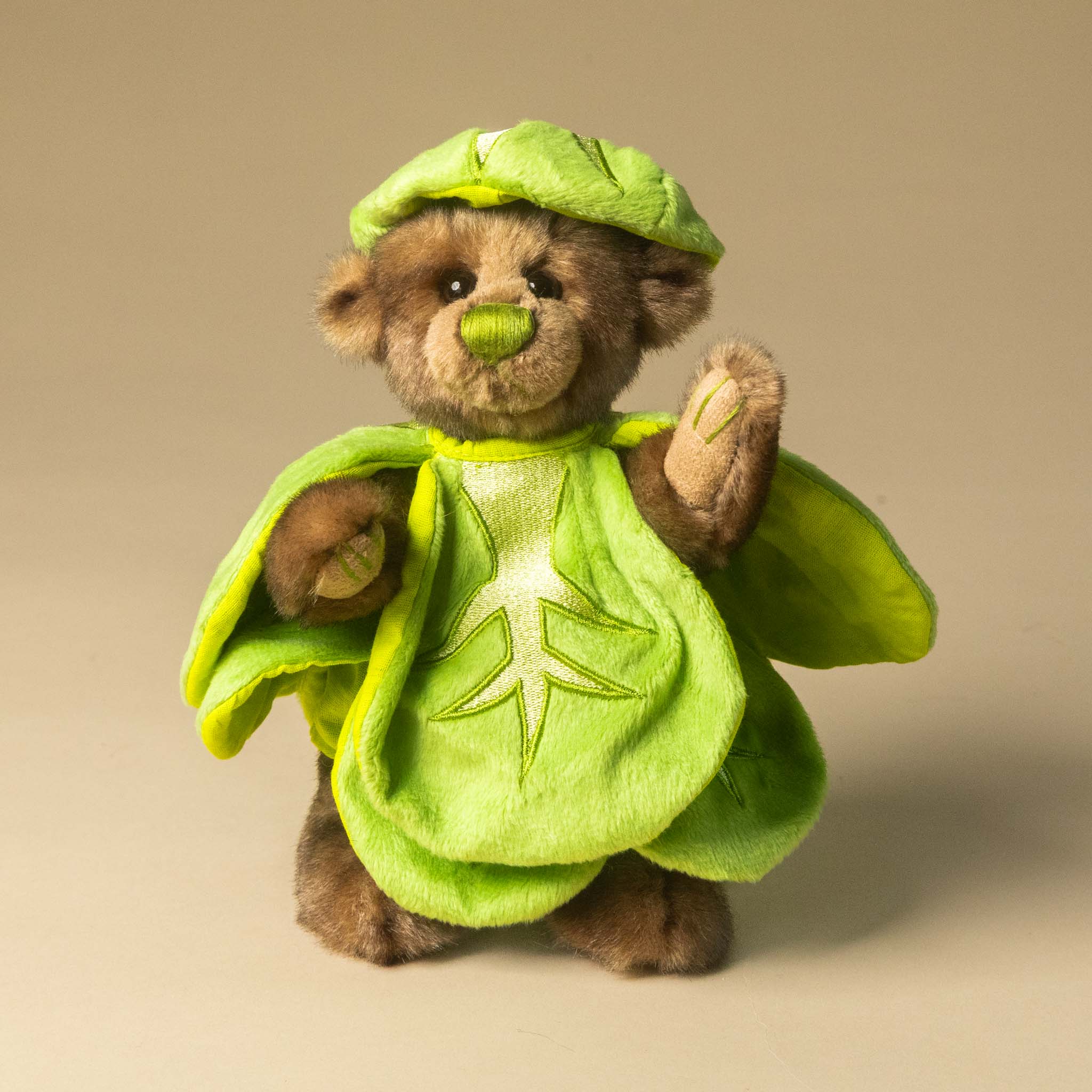 gustus-bear-the-brussel-sprout in a green leaf costume on a beige background