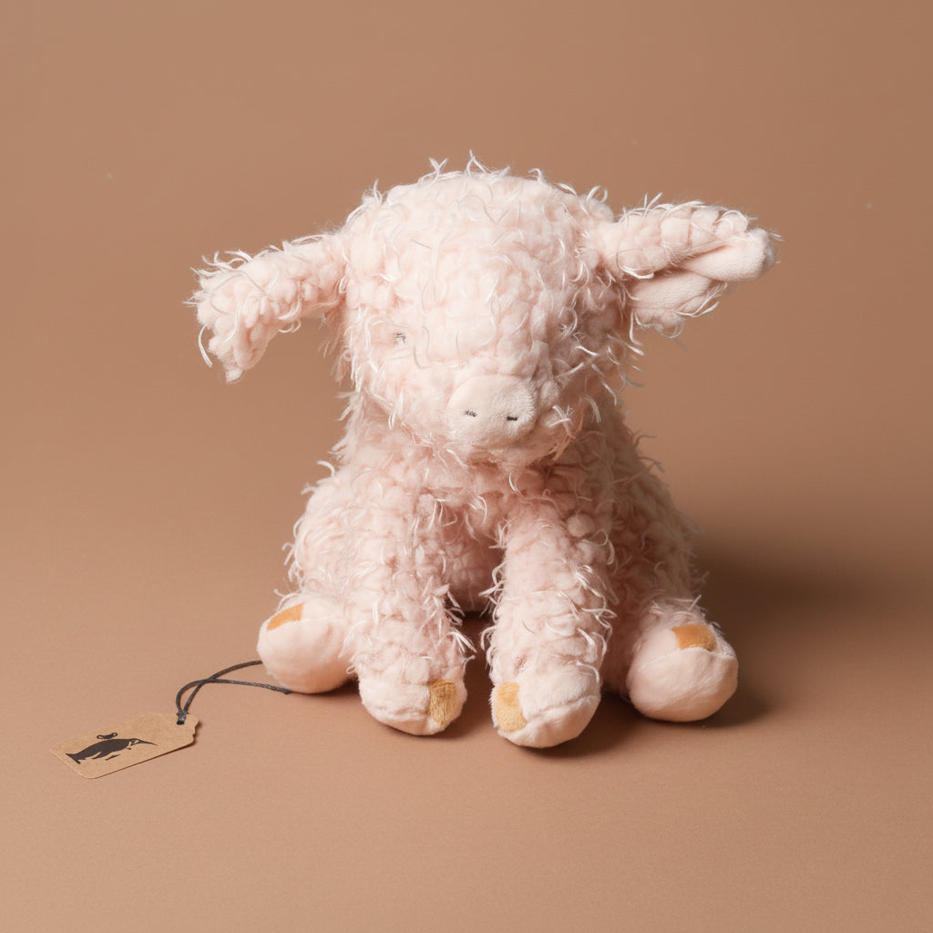 Pink plush hammie-the-pig-medium loy with a tag on a brown background