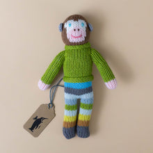 Load image into Gallery viewer, hand-knit-rattle-pierre-monkey-with-green-sweater-and-striped-blue-green-and-brown-pants