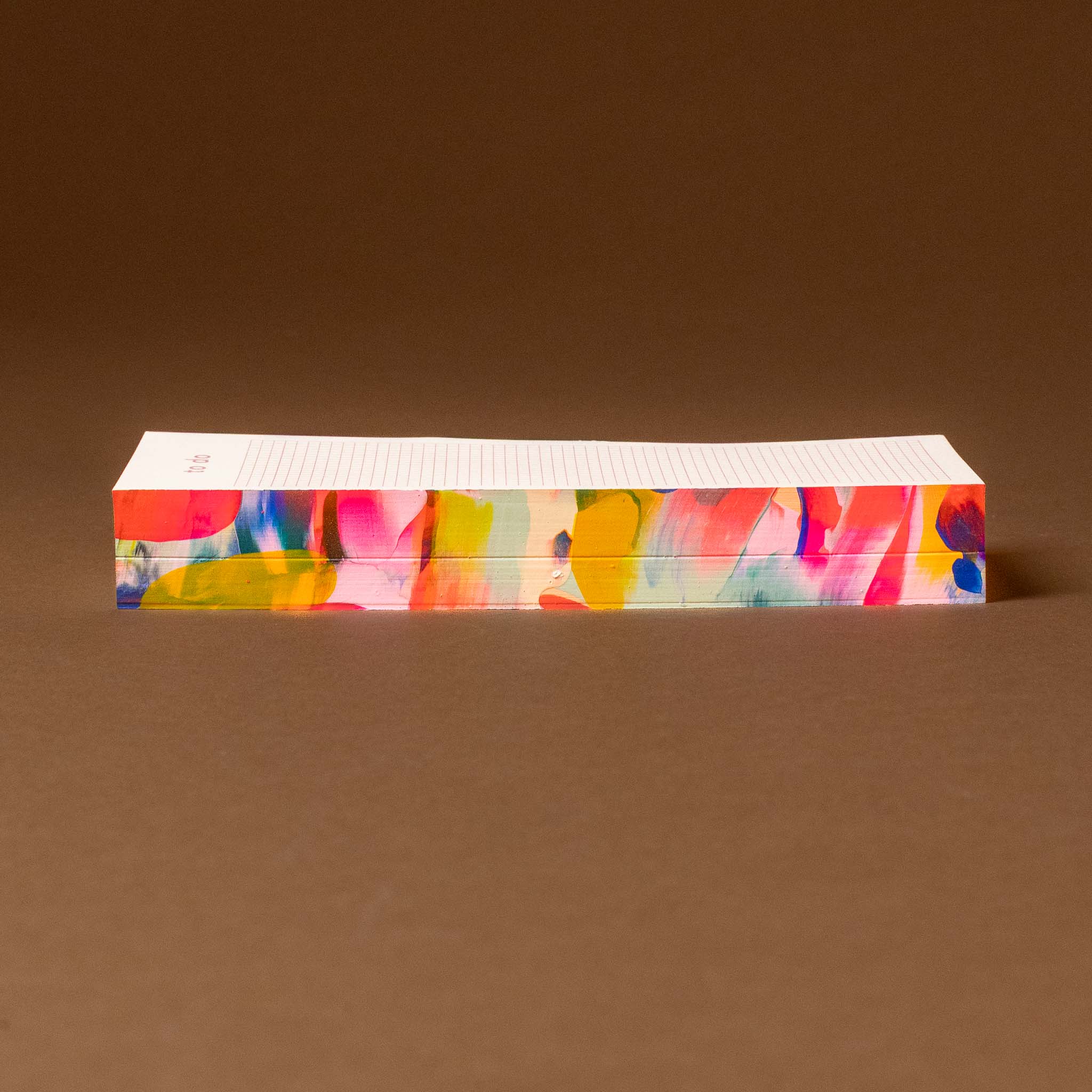 Colorful rectangular hand-painted-notepad-slim-to-do with abstract design on a brown background