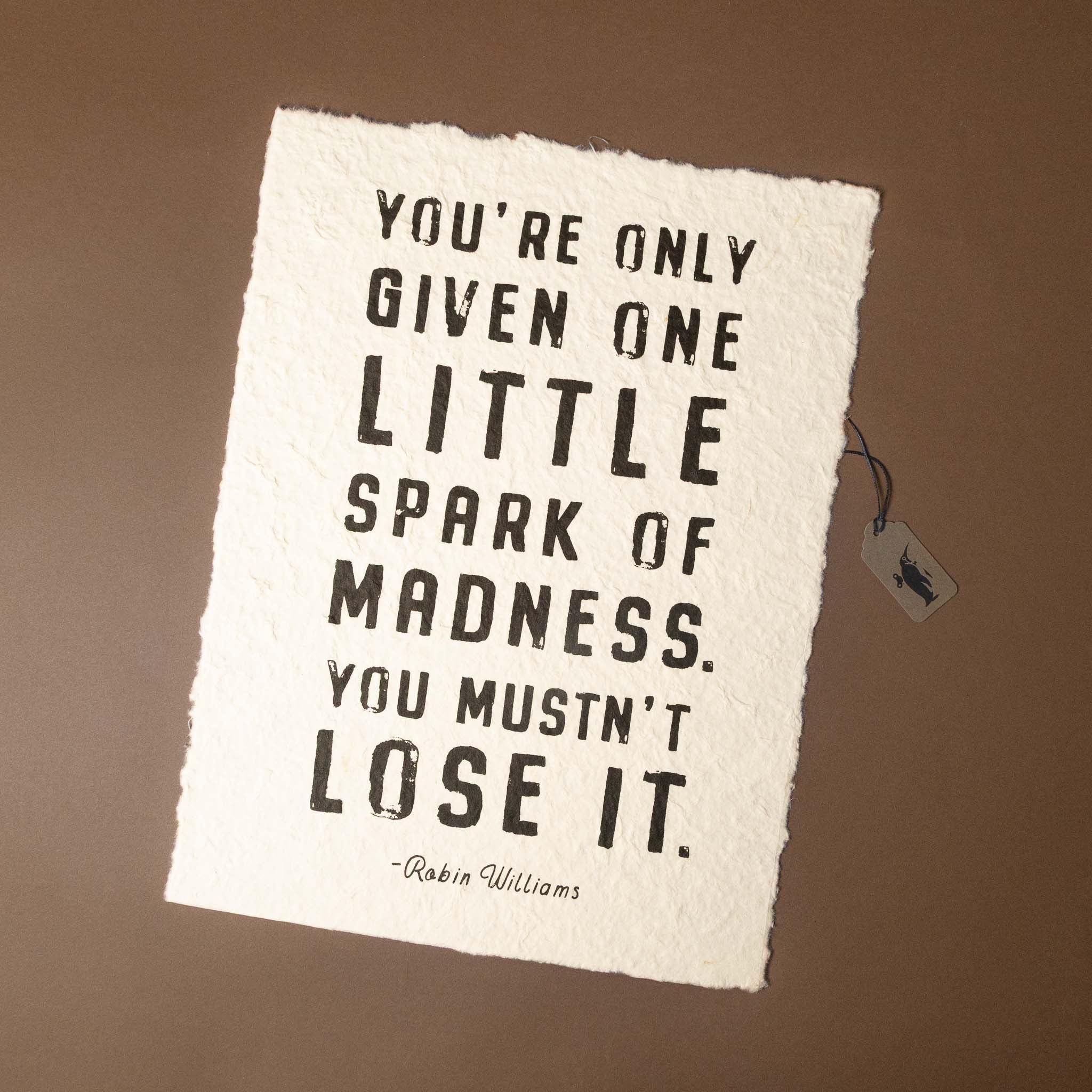 Motivational quote on a textured paper with a tag on a brown background
