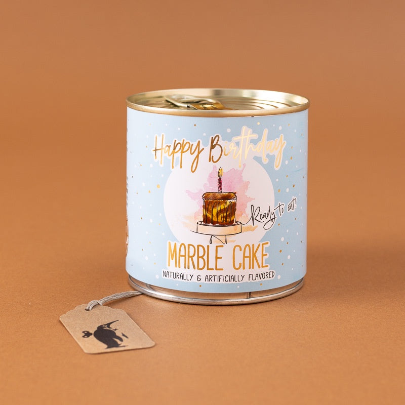 happy-birthday-cancake-marble-cake featuring a light blue label with a birthday cake illustration and the text 'Happy Birthday Marble Cake'. A small paper tag with a black cat silhouette hangs from the side.