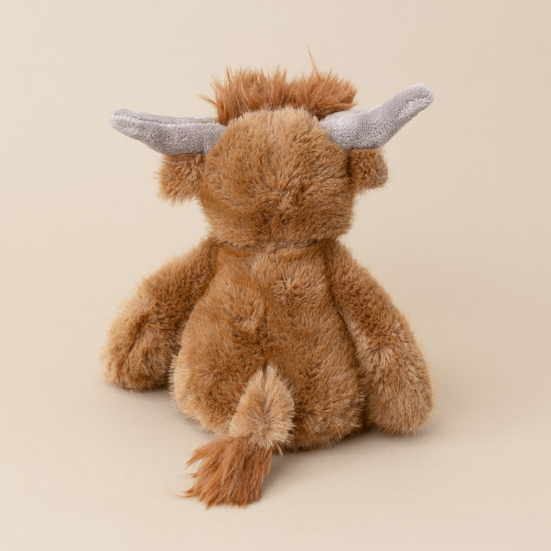 A brown plush stuffed animal shaped like a horned creature, shown from the back on a plain beige studio background.