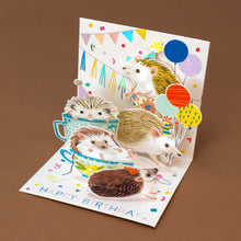 Load image into Gallery viewer, brimming-teacups-full-of-five-party-hat-wearing-hedgehogs-decorating-with-garland-and-tinsel-while-wishing-a-heartfelt-&quot;Happy-Birthday&quot;-in-colorful-letters