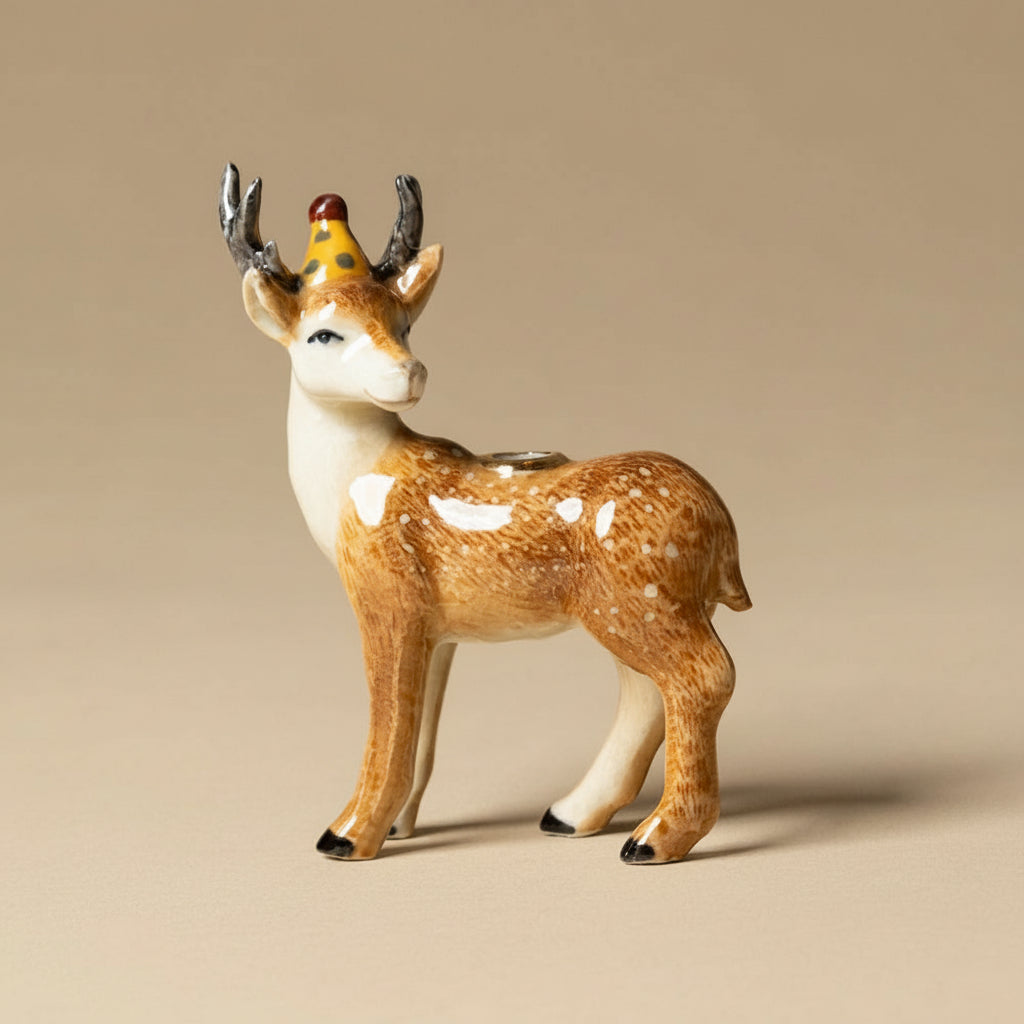 heirloom-porcelain-cake-topper-stag Deer figurine with a party hat on a beige background