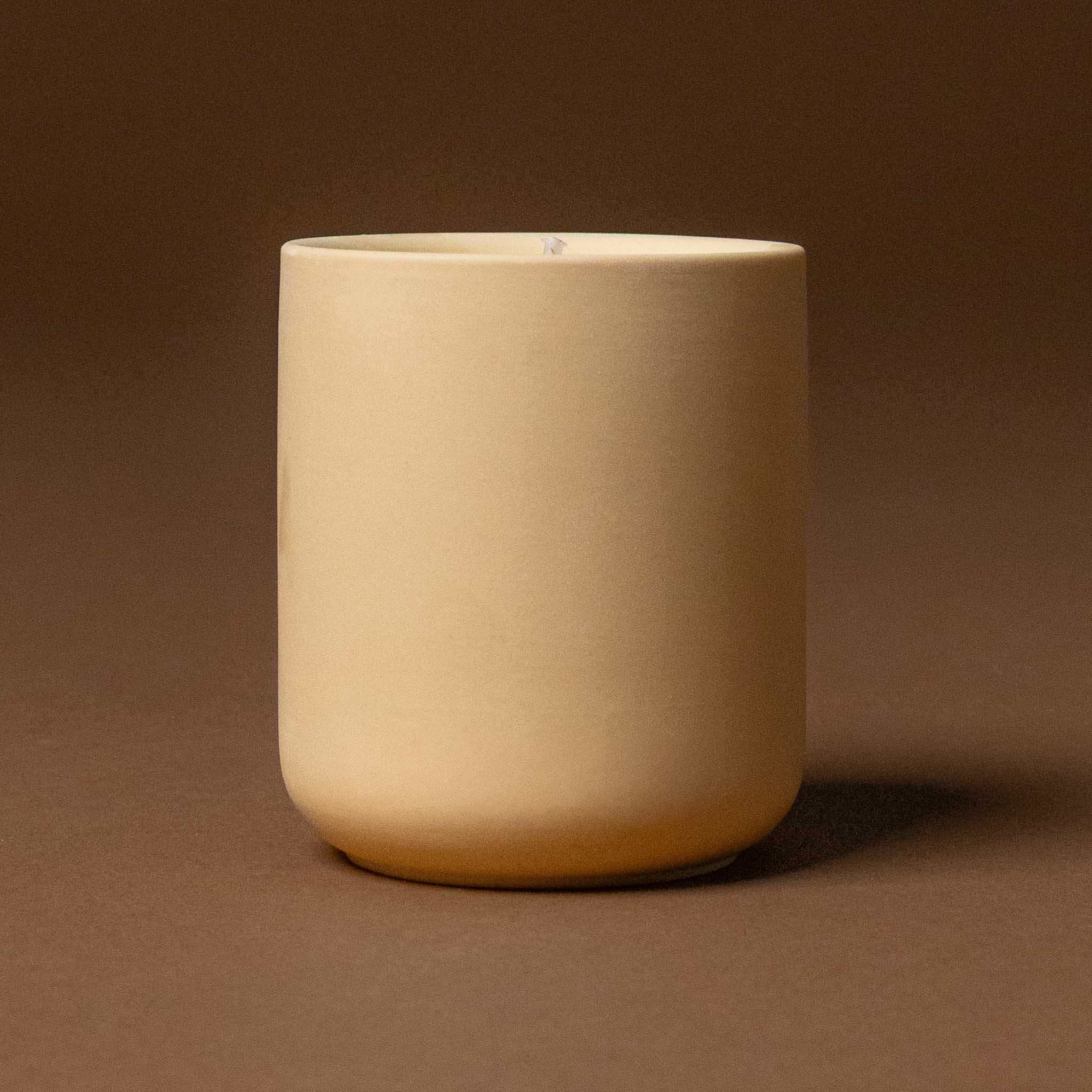 himalayan-cedarleaf-votive Beige ceramic  pot on a brown background