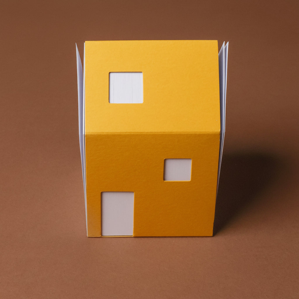 Yellow cardboard box with cut-out windows on a brown background