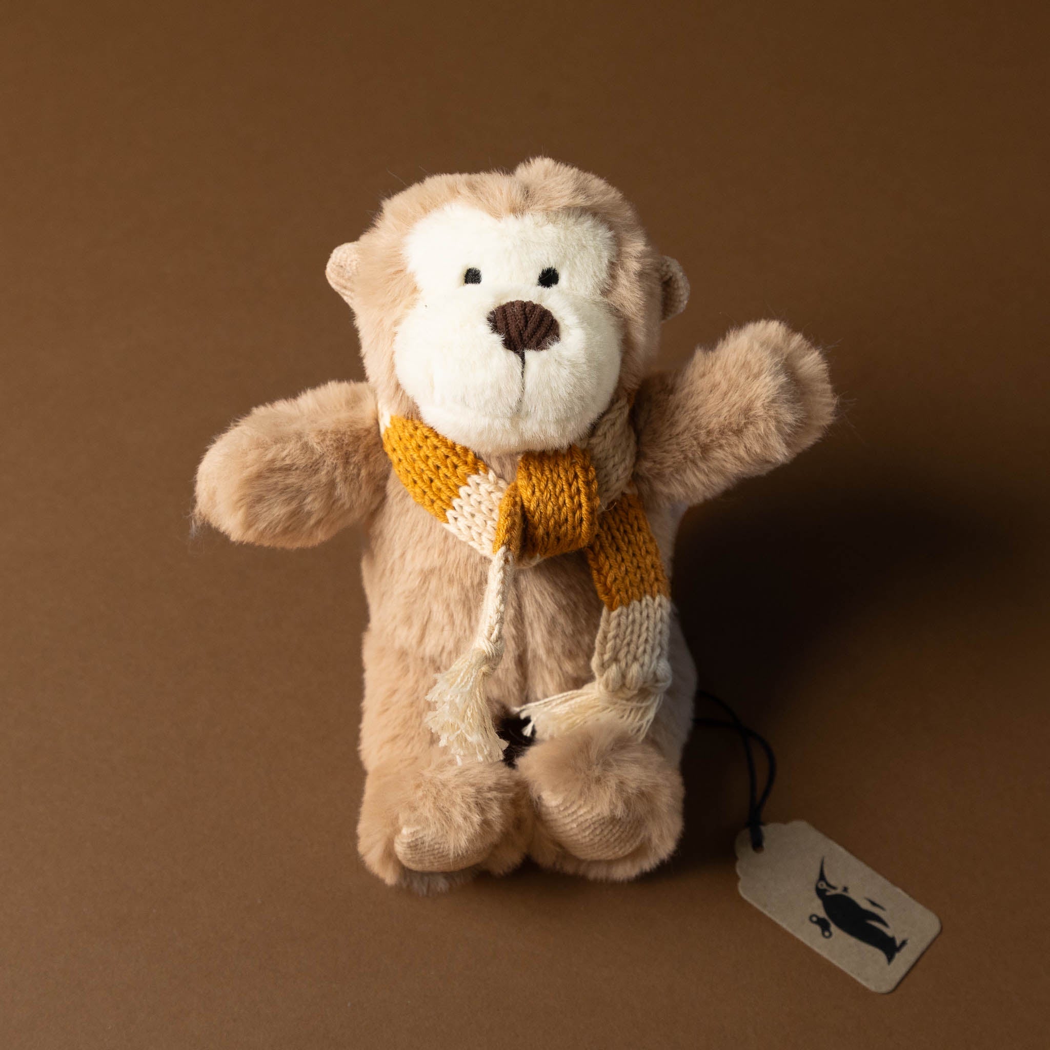 hugo-the-monkey Stuffed animal toy with a yellow scarf on a brown background
