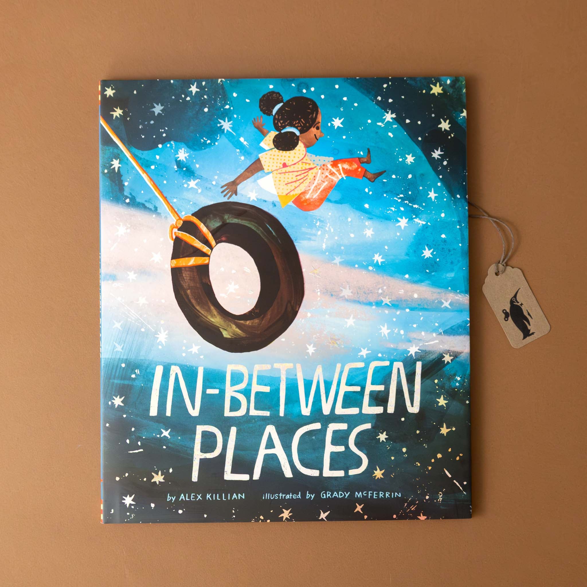 in-between-places-book-cover-with-a-girl-on-a-tire-swing-jumping-of-into-sparkling-space