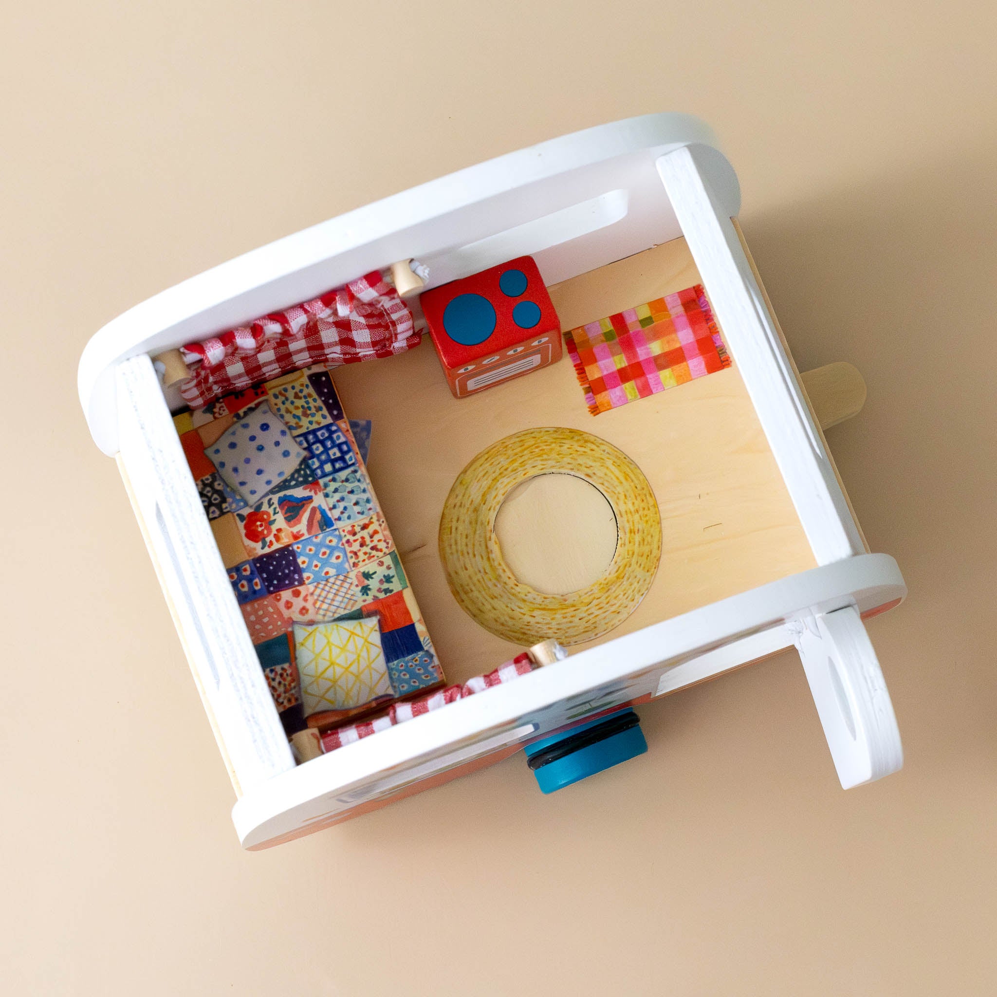 la-grande-famille-wooden-camper-play-set-interior-showing-cot-rugs-and-stove-with-red-gingham-curtains