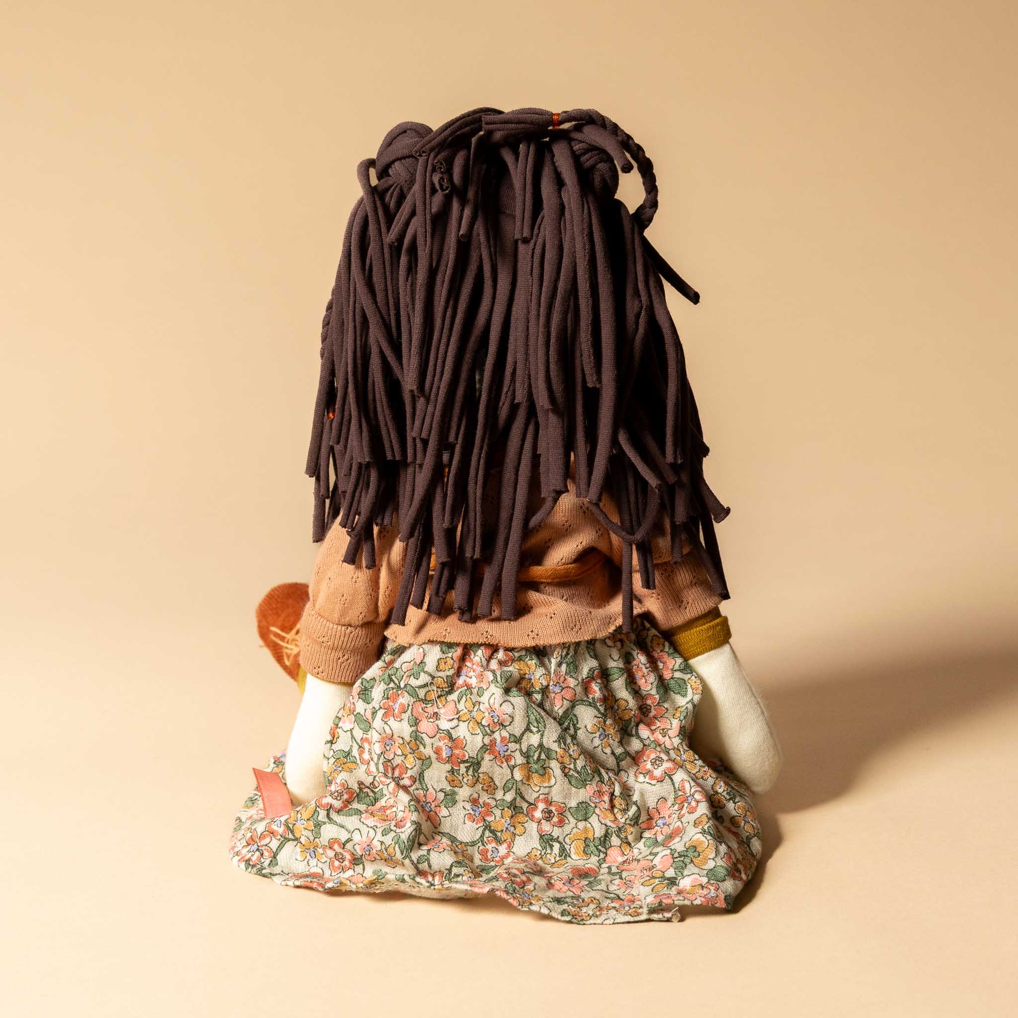 les-rosalie-rag-doll-marjolaine Doll with long hair and floral dress on a beige background