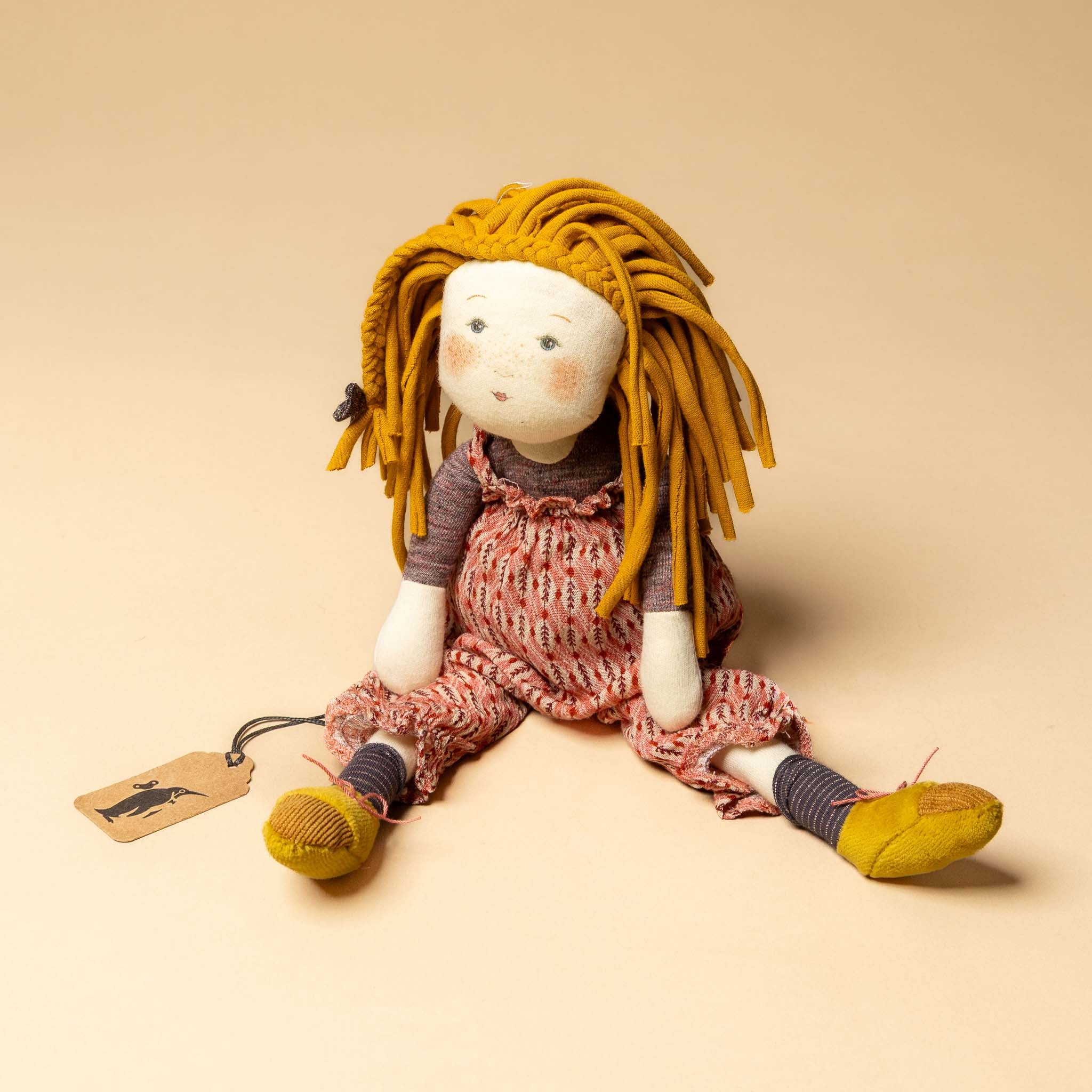 les-rosalie-rag-doll-vanille Textile doll with yellow hair and a pink dress on a beige background