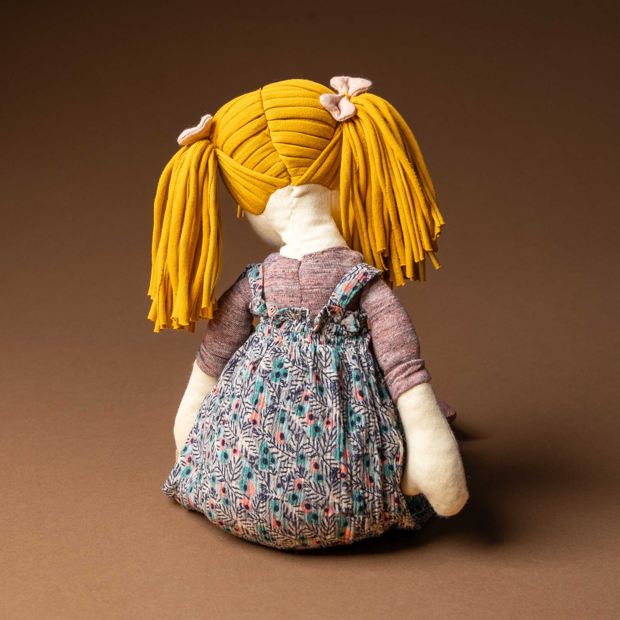les-rosalies-rag-doll-violette Textile art doll with yellow hair and a floral dress on a brown background