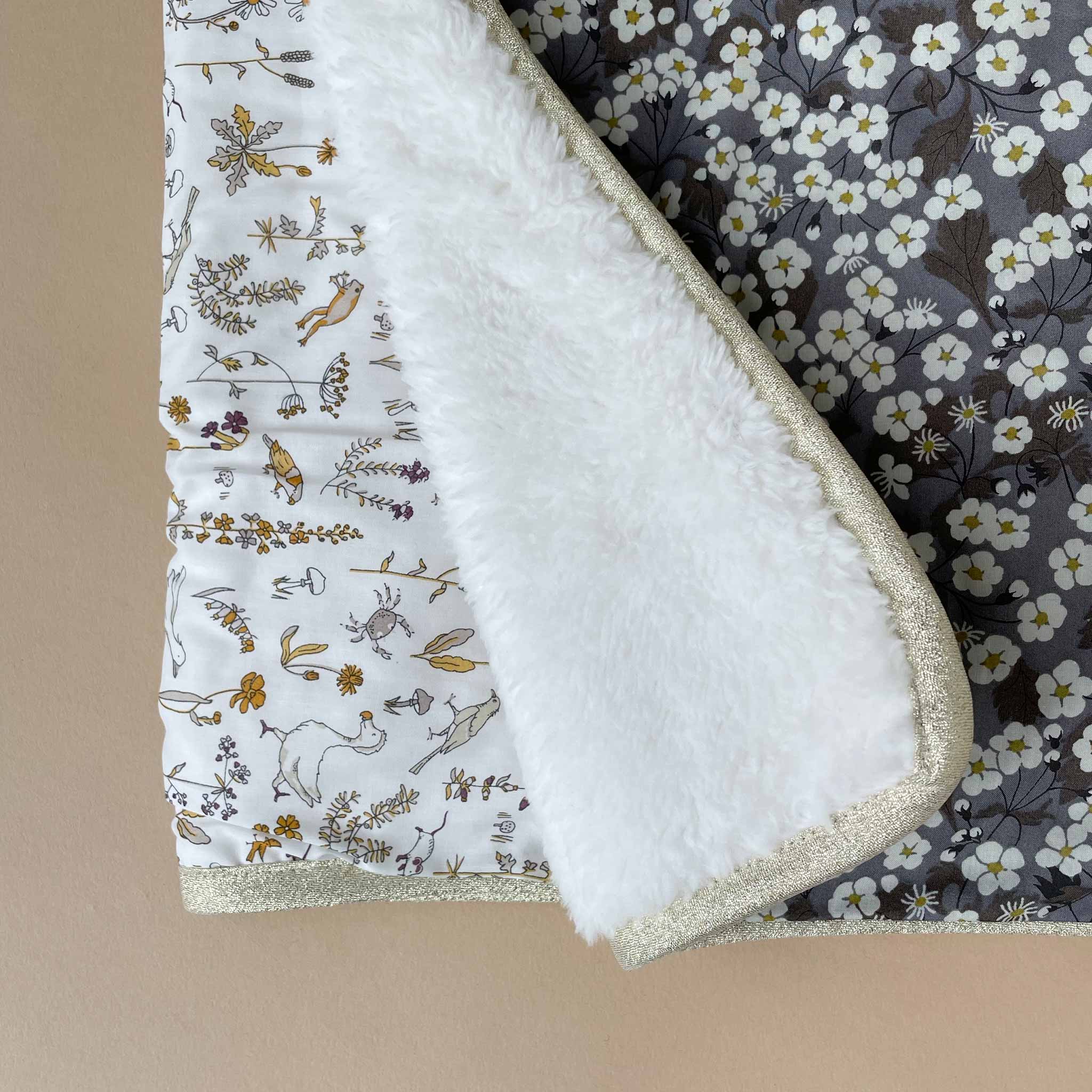 liberty-blanket-camille-with-soft-browns-yellows-and-white-floral-fabric-and-sherpa-lining-with-gold-lame-binding