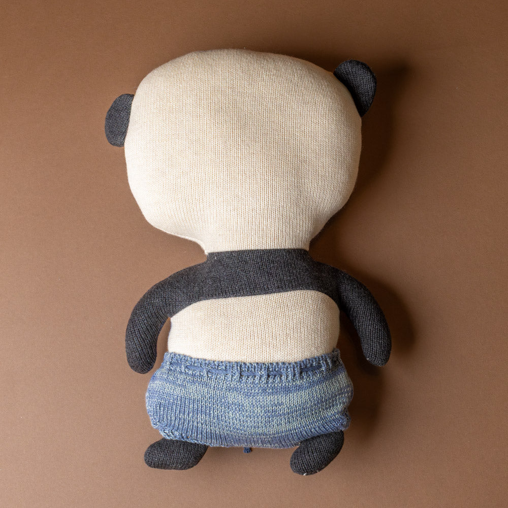 ling-ling-panda-bear Stuffed animal toy with blue pants on a brown background