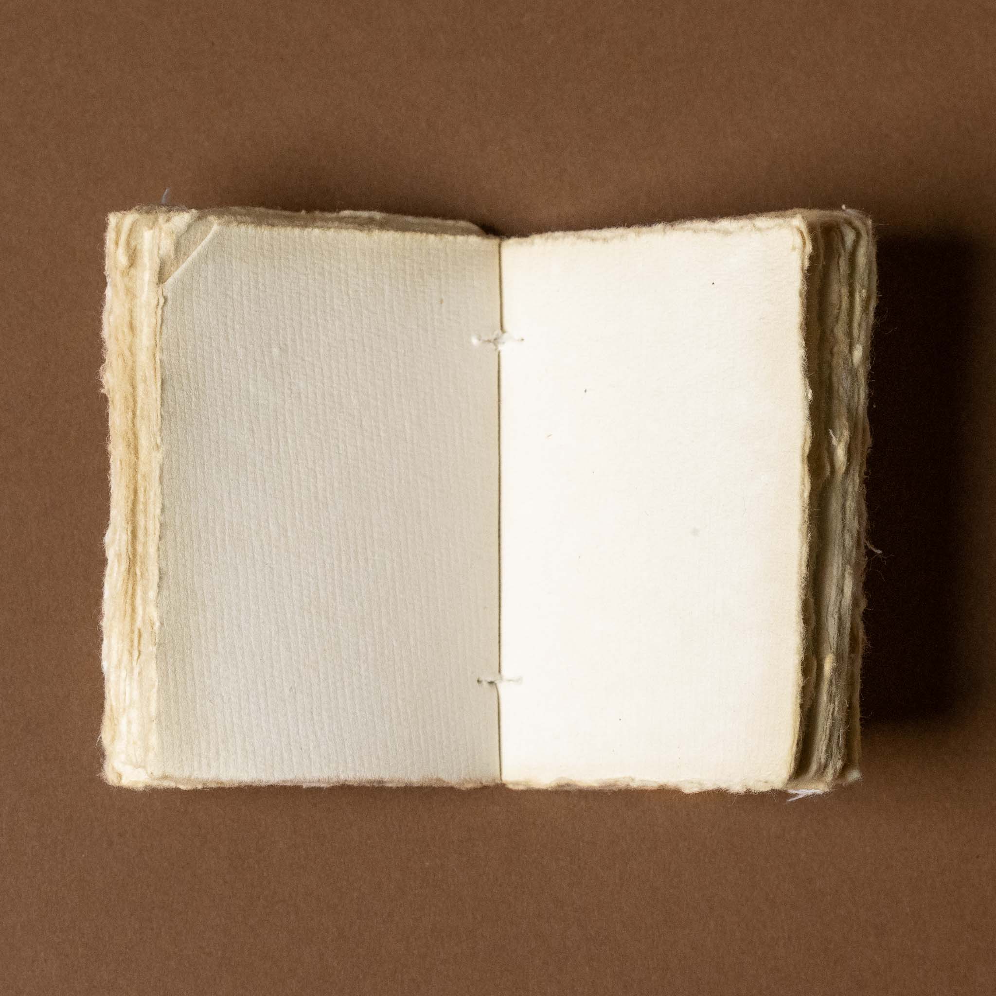 Open book with textured pages on a brown background