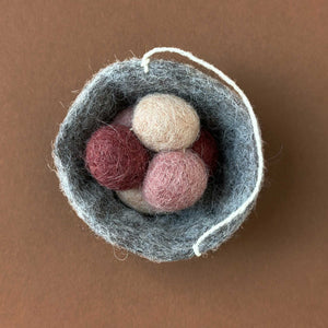 grey felted nest ornament with three little beige and rose eggs