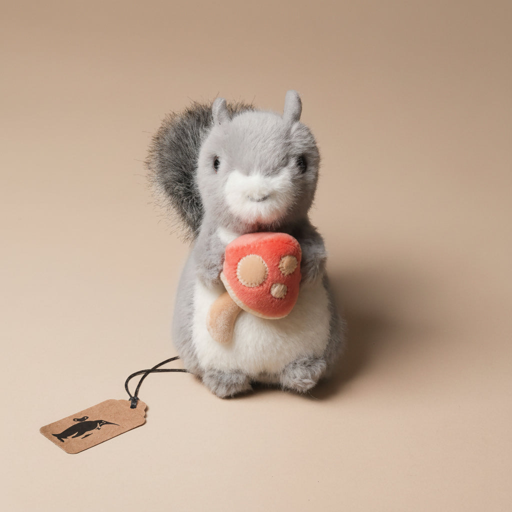 Plush toy little-grey-squirrel-with-toadstool on a beige background