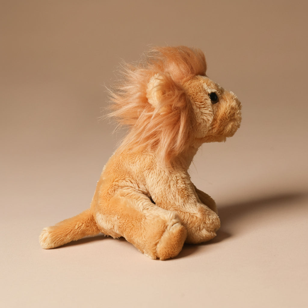 Plush little-lion-cub toy on a beige background