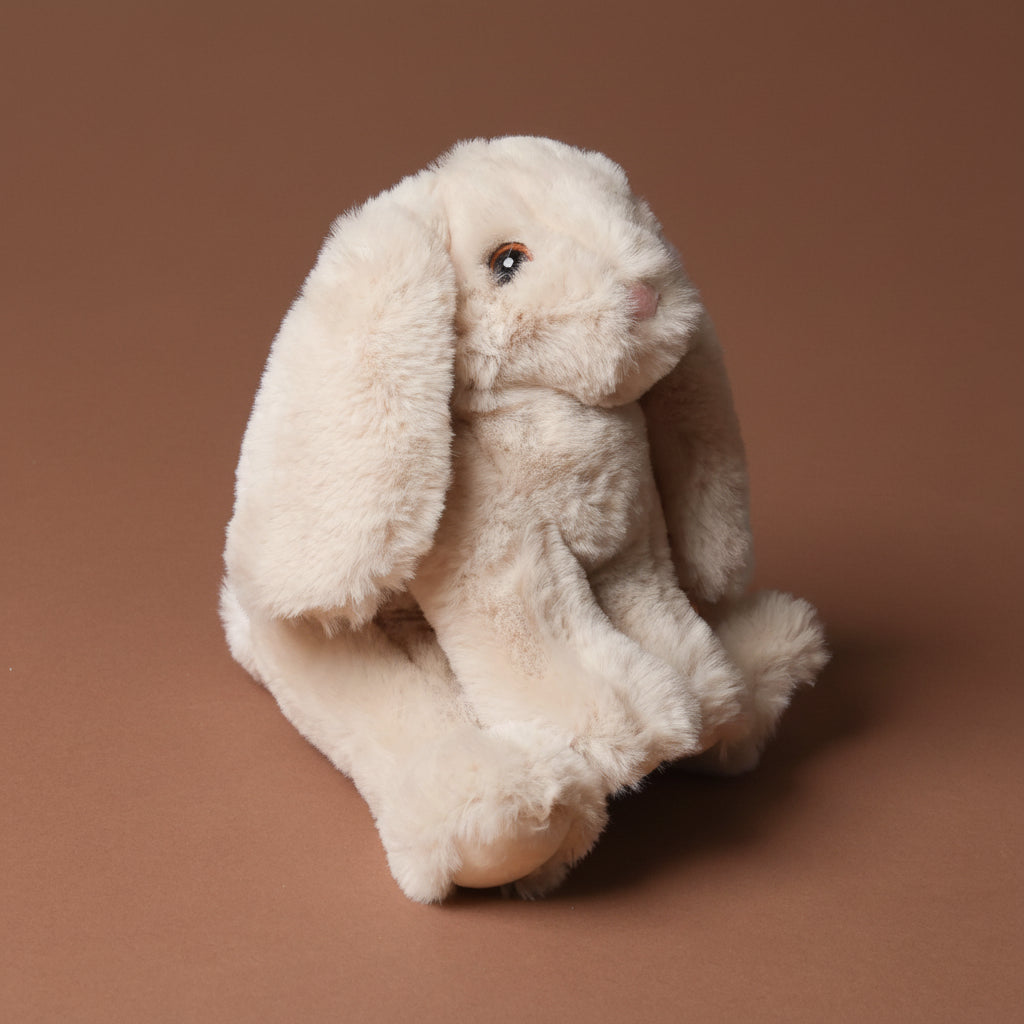 Plush toy little-lottie-bunny-beige on a brown background
